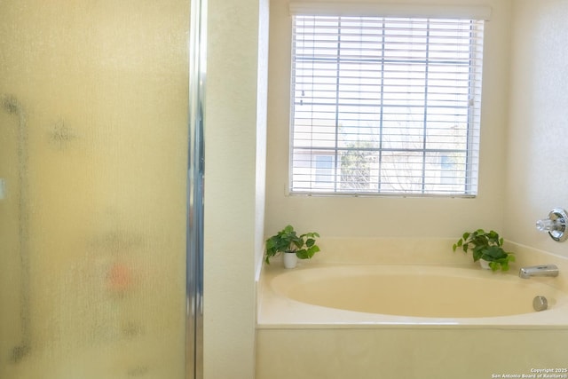 bathroom featuring plus walk in shower and a wealth of natural light