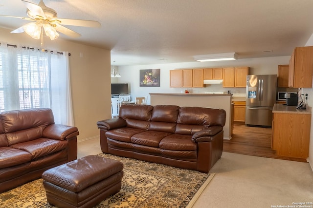 carpeted living room with ceiling fan