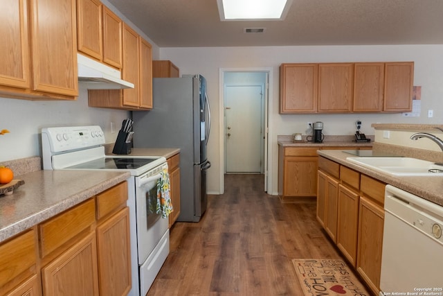 kitchen featuring white appliances, dark hardwood / wood-style flooring, and sink