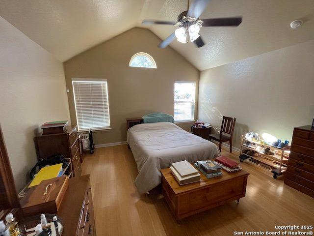 bedroom featuring lofted ceiling, ceiling fan, and light wood-type flooring