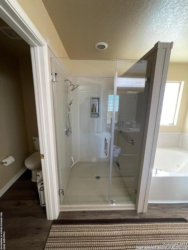 bathroom with toilet, hardwood / wood-style floors, a textured ceiling, and plus walk in shower