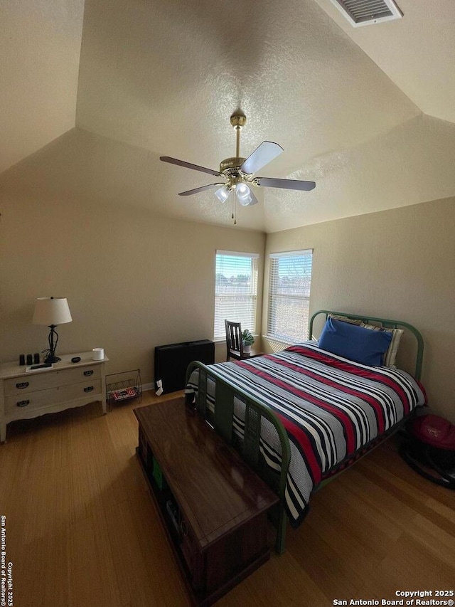 bedroom with hardwood / wood-style floors, a textured ceiling, and ceiling fan