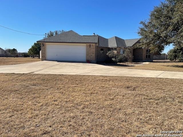 single story home with a garage and a front lawn