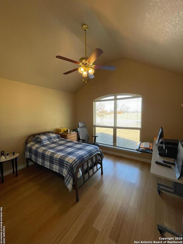 bedroom featuring hardwood / wood-style floors, vaulted ceiling, and ceiling fan