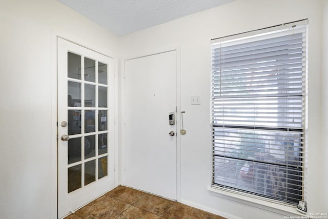 tiled foyer entrance featuring a textured ceiling