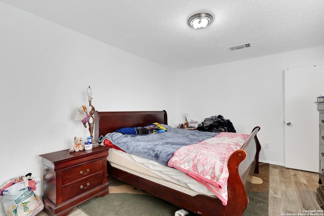 bedroom featuring a textured ceiling and light wood-type flooring