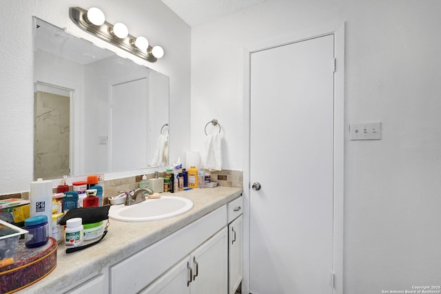 bathroom with vanity, backsplash, and a textured ceiling