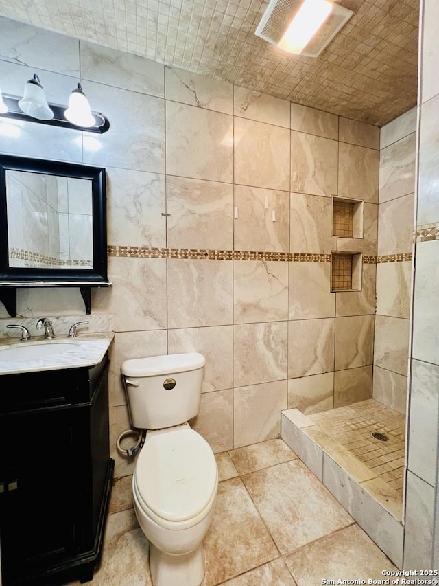 bathroom featuring brick ceiling, tile walls, vanity, toilet, and walk in shower