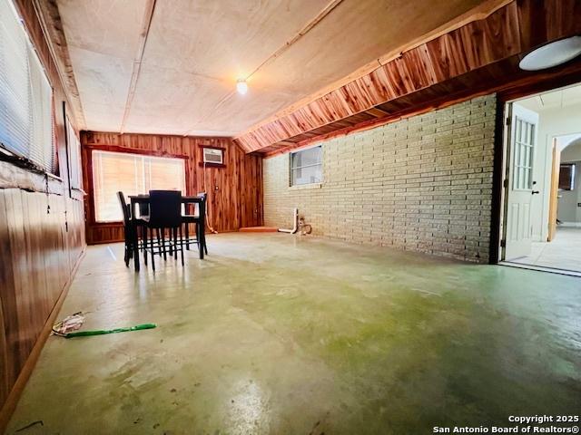 interior space featuring brick wall and wood walls