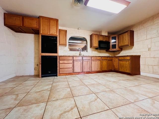 kitchen featuring sink, black appliances, and light tile patterned flooring