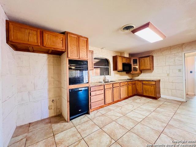 kitchen with sink, black appliances, and light tile patterned flooring