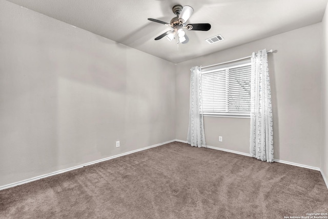 empty room featuring ceiling fan and dark carpet