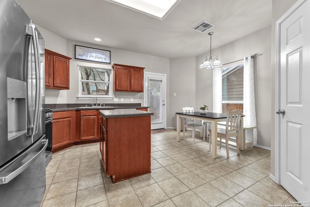 kitchen featuring pendant lighting, sink, an inviting chandelier, a center island, and stainless steel fridge with ice dispenser