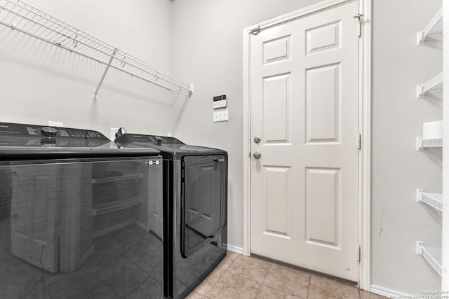 clothes washing area featuring light tile patterned flooring and independent washer and dryer