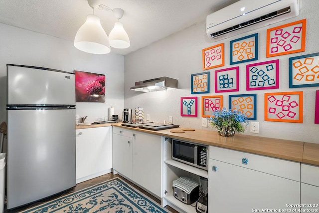 kitchen featuring white cabinetry, appliances with stainless steel finishes, butcher block counters, and an AC wall unit