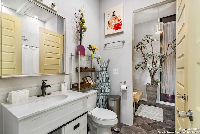 bathroom featuring vanity, tile patterned floors, and toilet