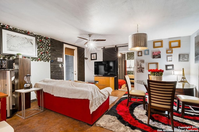 living room featuring a barn door and ceiling fan