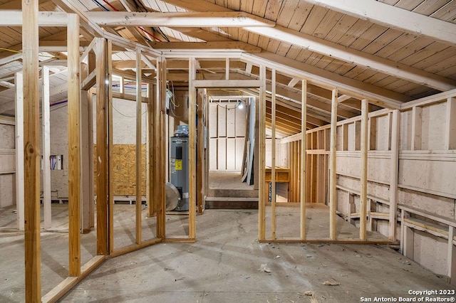 miscellaneous room with lofted ceiling and water heater