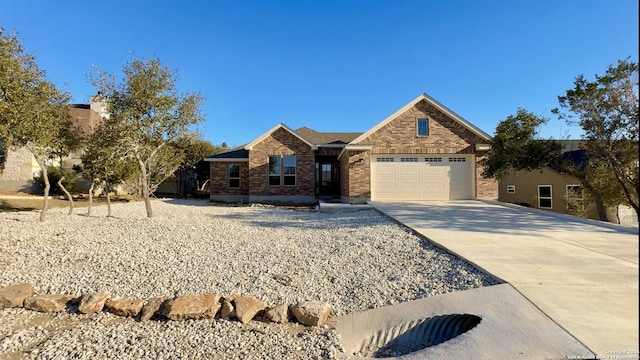 view of front of home featuring concrete driveway, an attached garage, and brick siding