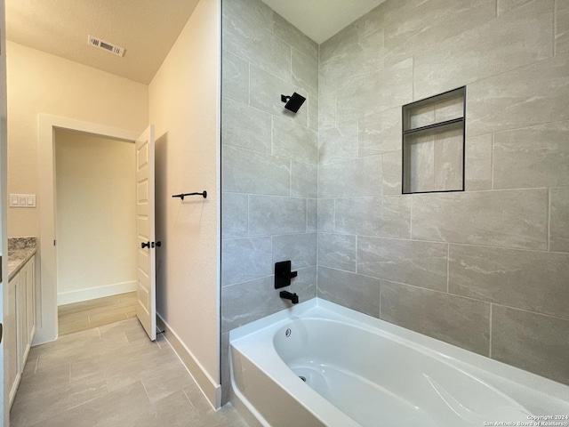 bathroom with vanity and tiled shower / bath combo