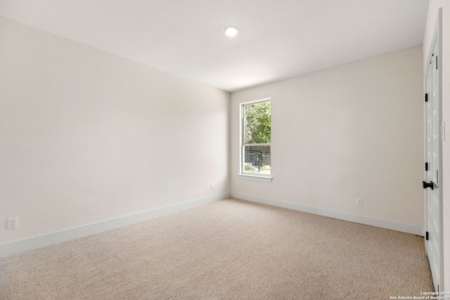 spare room featuring light carpet