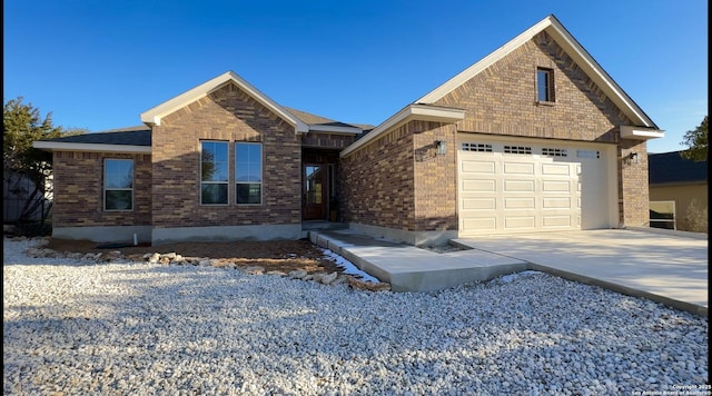 view of front of home featuring brick siding, driveway, and an attached garage