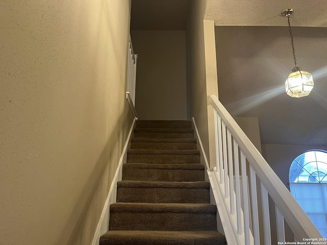 staircase with a textured ceiling