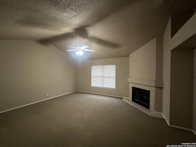 unfurnished living room with vaulted ceiling, a textured ceiling, ceiling fan, light colored carpet, and a fireplace