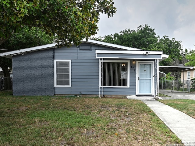 view of front of property featuring a carport and a front lawn