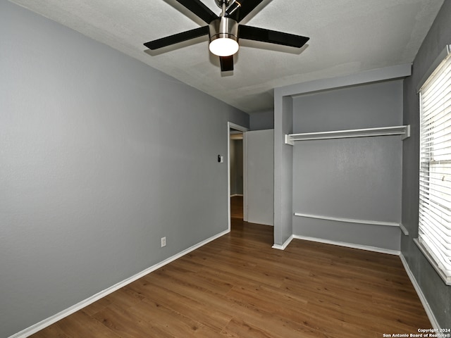 unfurnished bedroom featuring ceiling fan, wood-type flooring, and a closet