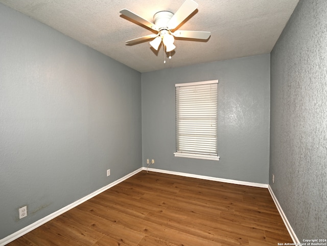 empty room featuring ceiling fan, hardwood / wood-style floors, and a textured ceiling