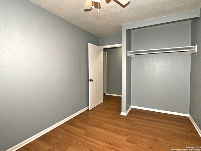 unfurnished bedroom featuring hardwood / wood-style flooring, a textured ceiling, a closet, and ceiling fan