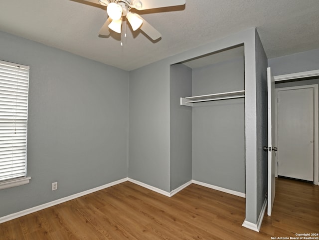 unfurnished bedroom with hardwood / wood-style flooring, a textured ceiling, a closet, and ceiling fan