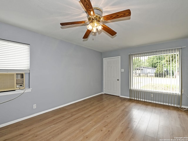 unfurnished room featuring cooling unit, ceiling fan, and light hardwood / wood-style flooring