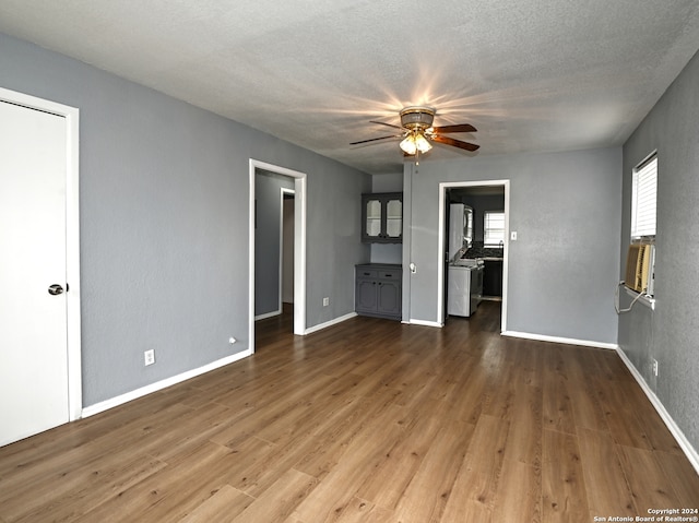 unfurnished living room featuring ceiling fan, cooling unit, a textured ceiling, and dark hardwood / wood-style flooring