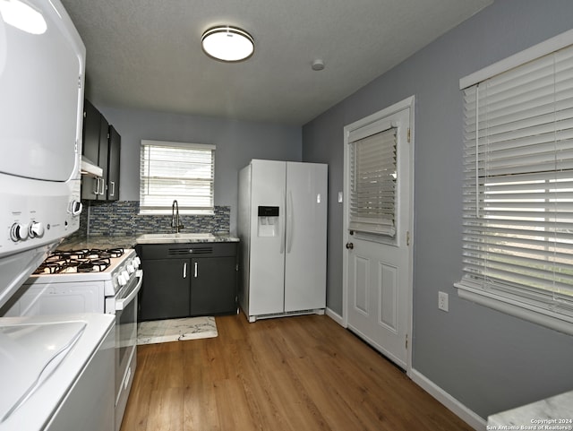 kitchen featuring light hardwood / wood-style floors, sink, white appliances, and decorative backsplash