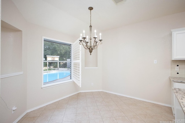 unfurnished dining area with an inviting chandelier