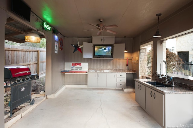 view of patio featuring grilling area, an outdoor kitchen, sink, and ceiling fan