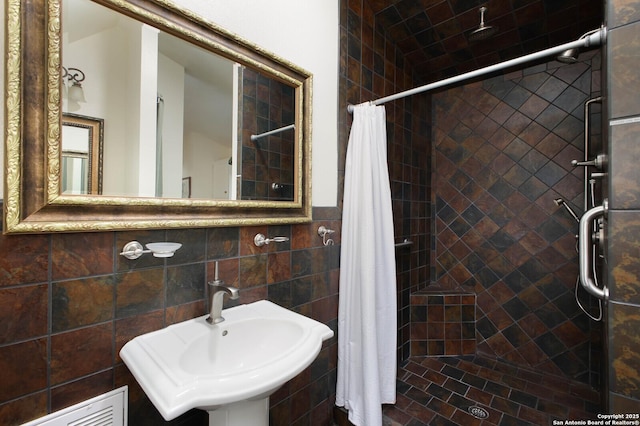 bathroom with tile walls, sink, backsplash, and a shower with curtain