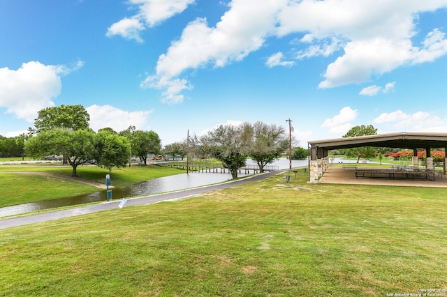 surrounding community with a water view and a yard