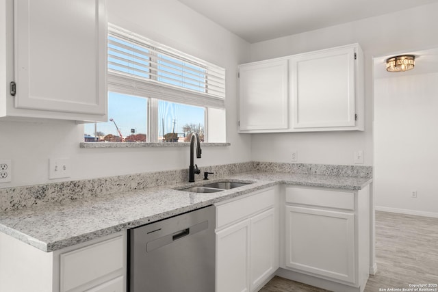 kitchen featuring white cabinetry, dishwasher, sink, light stone countertops, and light hardwood / wood-style flooring