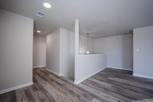 unfurnished room with dark wood-type flooring and a textured ceiling