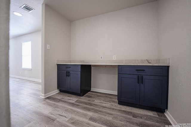 interior space with built in desk and light wood-type flooring