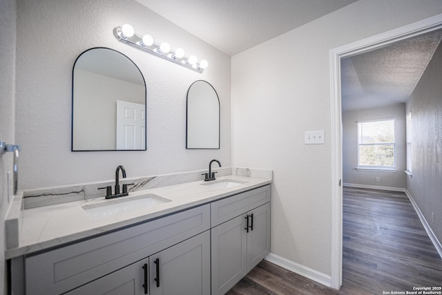 bathroom featuring hardwood / wood-style flooring, vanity, and a textured ceiling