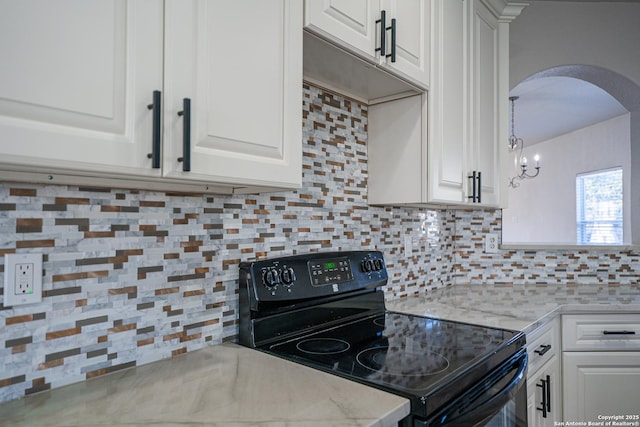 kitchen featuring light stone countertops, black electric range oven, decorative backsplash, and white cabinets