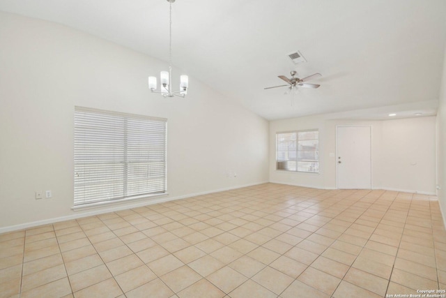 empty room with lofted ceiling, light tile patterned floors, and ceiling fan with notable chandelier