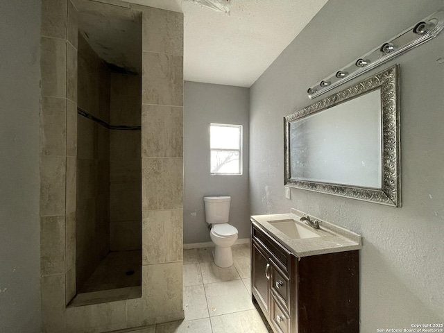 bathroom featuring vanity, a textured ceiling, a shower, tile patterned floors, and toilet