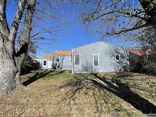 rear view of house featuring a yard