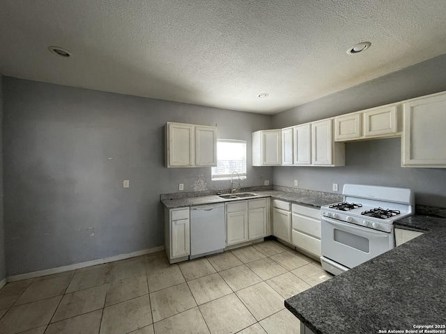 kitchen featuring sink, light tile patterned floors, white cabinets, and white appliances