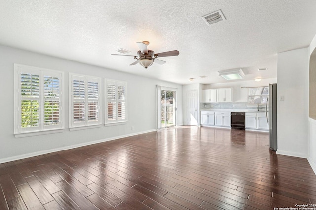 unfurnished living room with a wealth of natural light, dark hardwood / wood-style floors, and ceiling fan